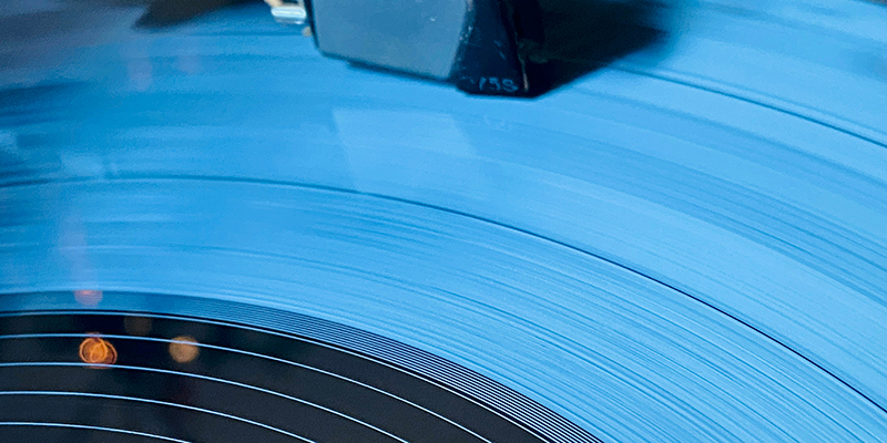 A extreme close-up of a vinyl record's surface, showing the microscopic grooves that represent physical data for sound.